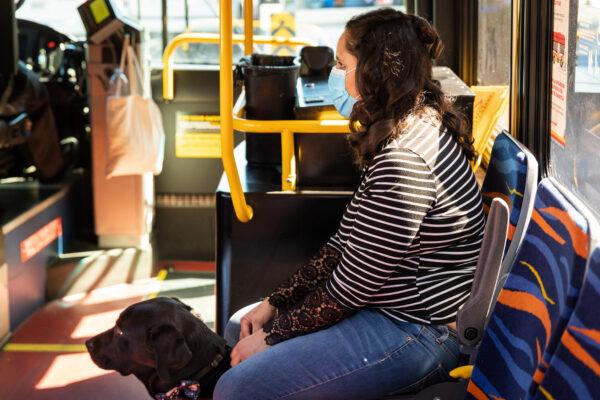 Ezzie Davis and her dog, Calypso, ride the bus in Long Beach, Calif., on Feb. 24, 2021. (John Fredricks/The Epoch Times)