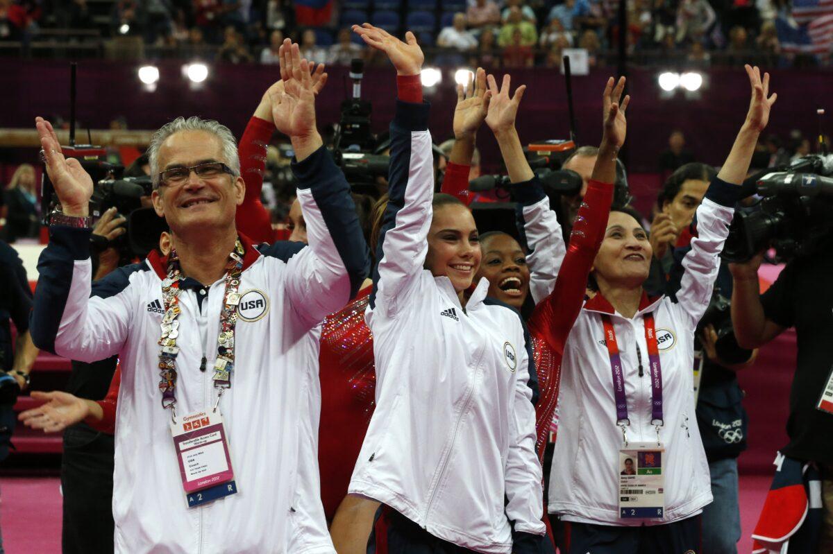 U.S. gymnasts Gabrielle Douglas (C), Mckayla Maroney (2D-L), coaches Jenny Zhang (R) and John Geddert (L) celebrate winning gold in the women's team of the artistic gymnastics event of the London Olympic Games on July 31, 2012. (Thomas Coex/AFP via Getty Images)