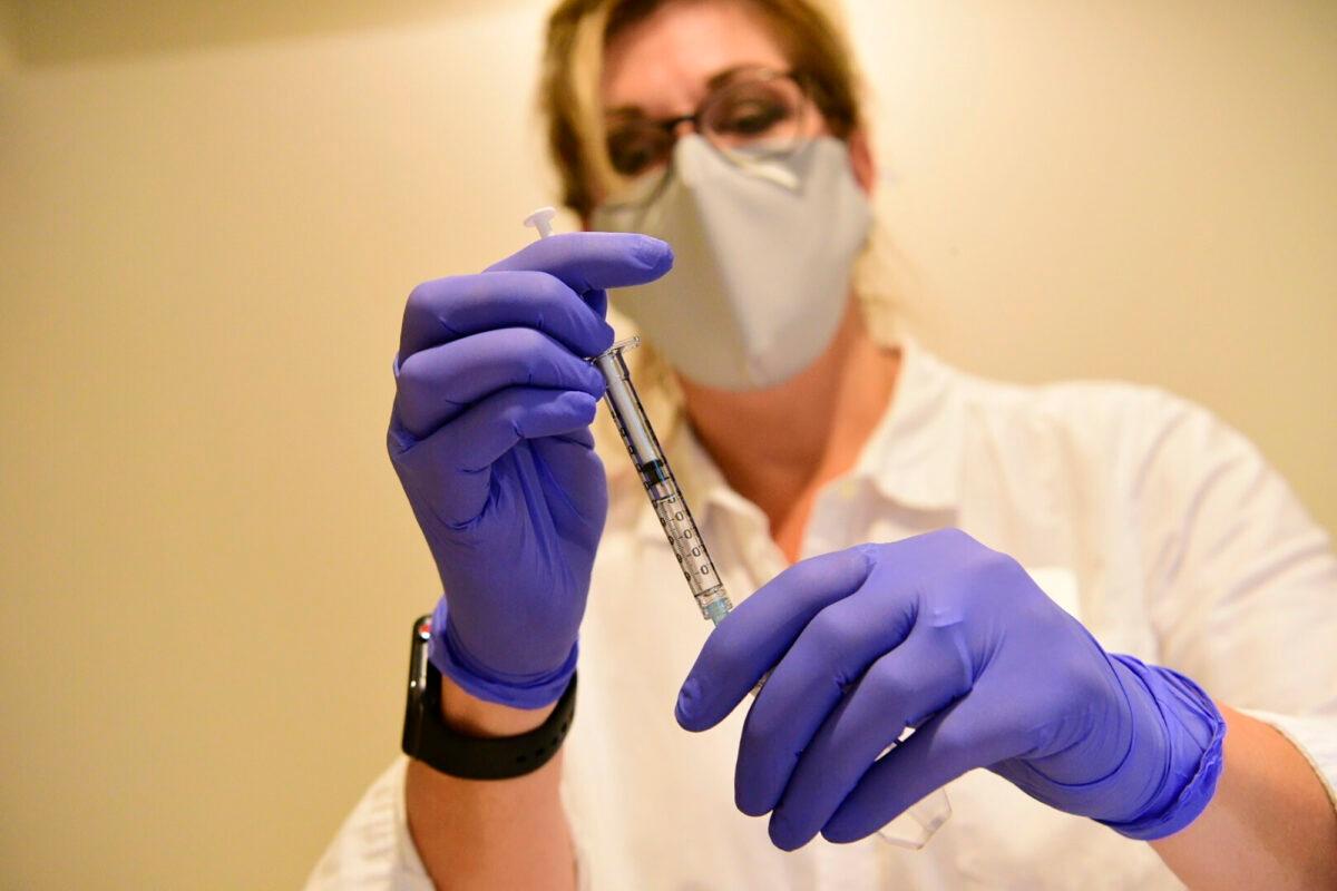 A pharmacist prepares to give an experimental COVID-19 vaccine in a file photo. (Johnson & Johnson via AP)