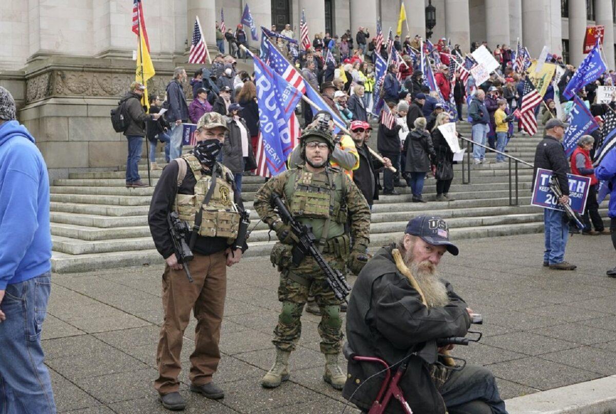 Two men stand armed with guns at a protest in Olympia, Wash., on Jan. 6, 2021. (Ted S. Warren/AP Photo)