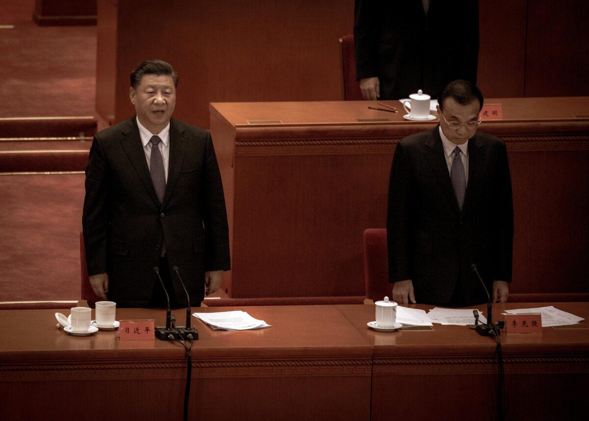 Chinese Leader Xi Jinping (L) and Premier Li Keqiang sing the national anthem at a ceremony marking the 70th anniversary of China's entry into the Korean War, at the Great Hall of the People in Beijing, China on Oct. 23, 2020. (Kevin Frayer/Getty Images)