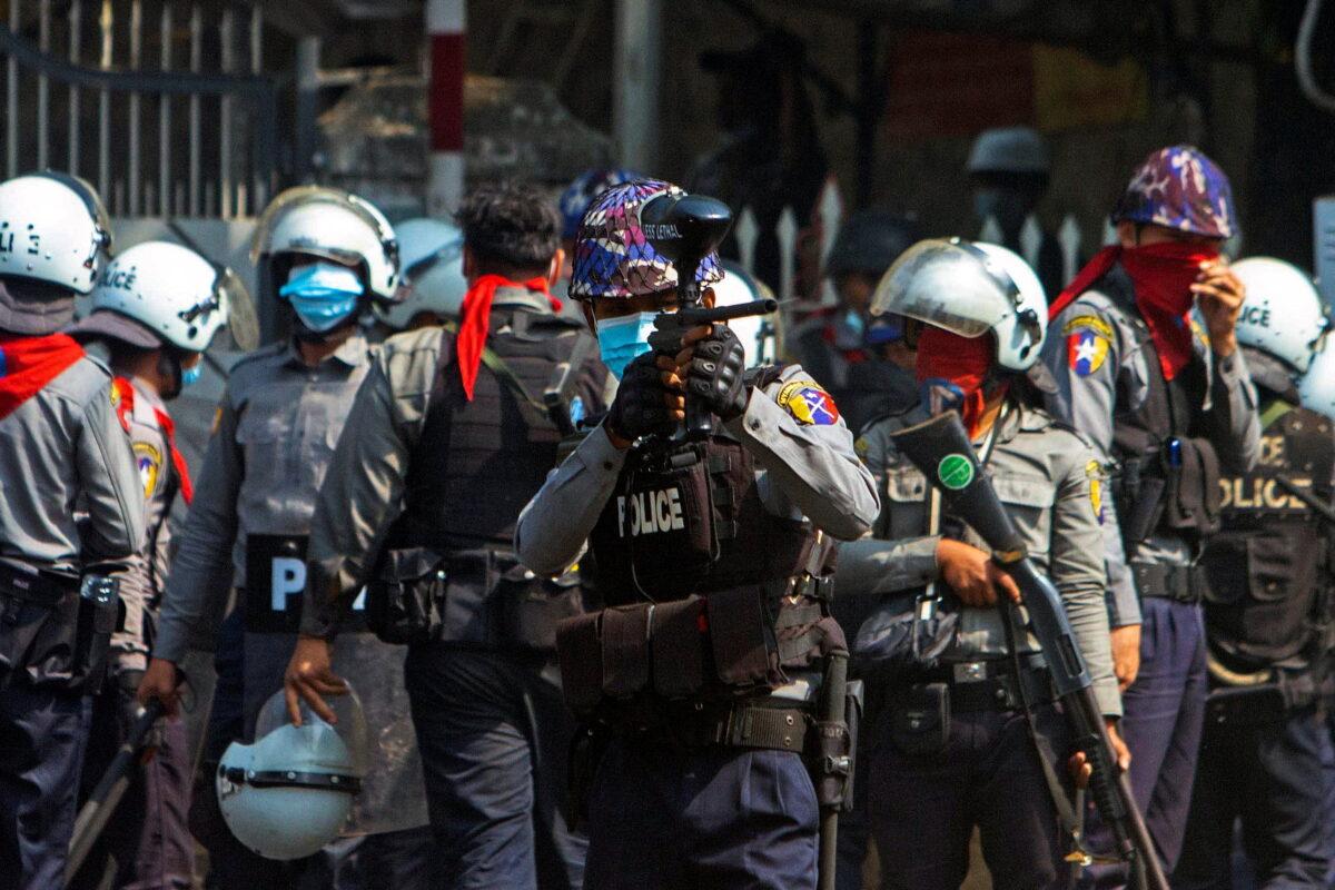 A riot police officer fires a rubber bullet toward protesters during a protest against the military coup in Yangon, Burma, on Feb. 28, 2021. (Stringer via Reuters)