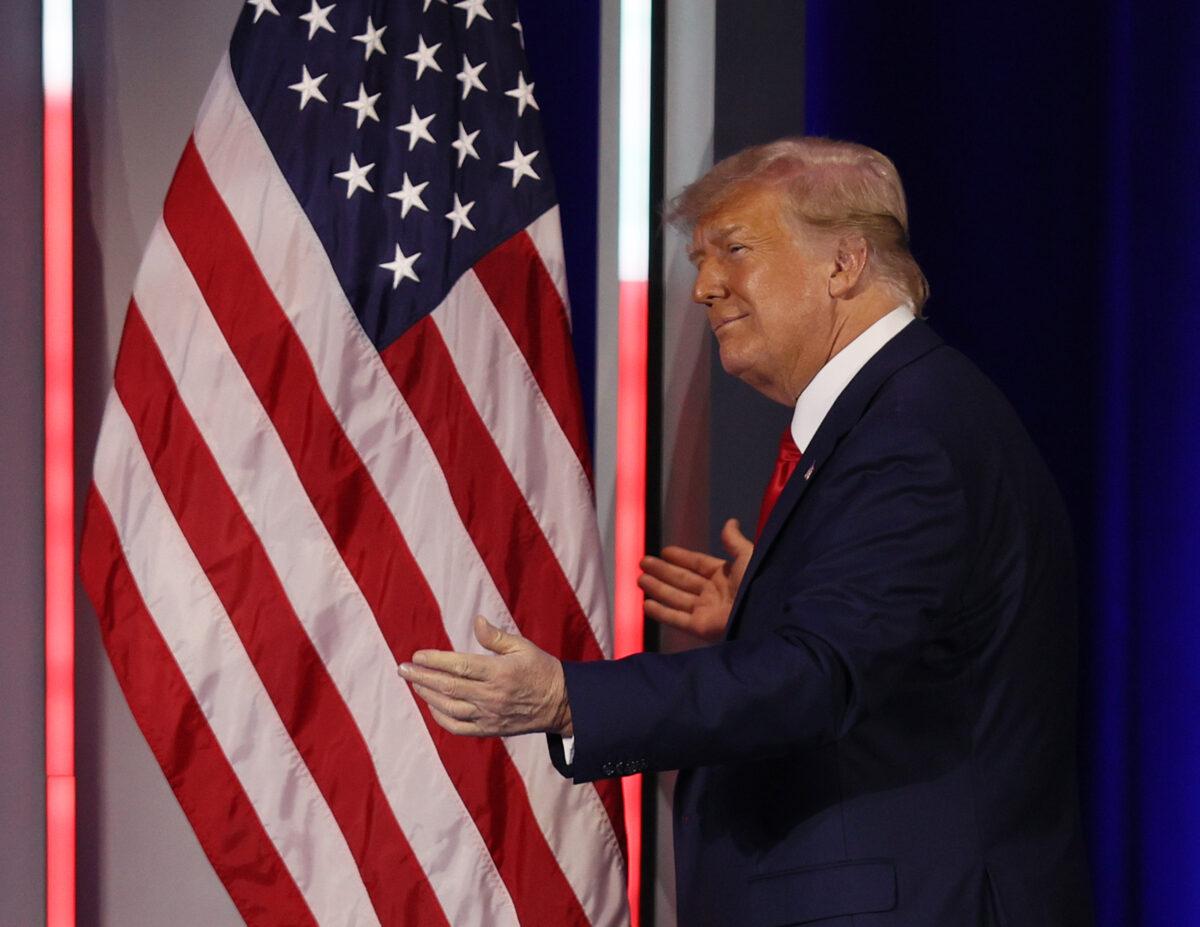 Former President Donald Trump embraces the American flag as he arrives on stage to address the Conservative Political Action Conference held in the Hyatt Regency in Orlando, Fla., on Feb. 28, 2021. (Joe Raedle/Getty Images)