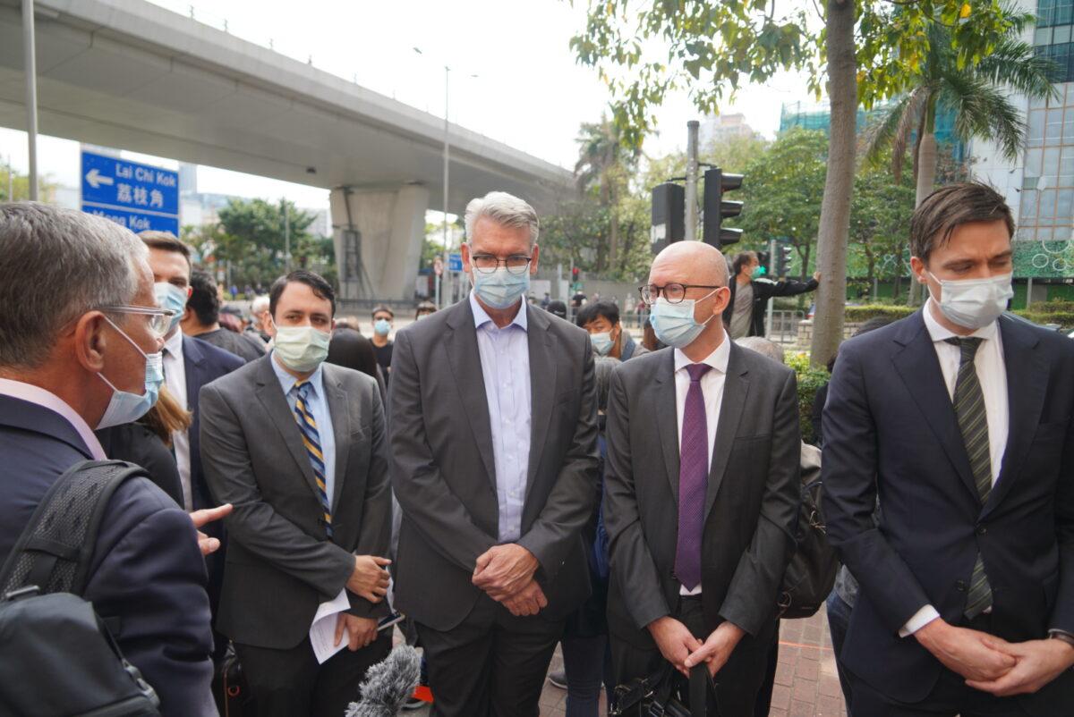 Foreign diplomats queue outside the West Kowloon Magistrates' Courts, where 47 dissidents charged under the Beijing-imposed national security law appeared in court, in Hong Kong, on March 1, 2021. (Adrian Yu/The Epoch Times)