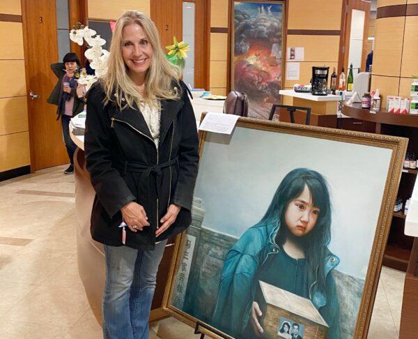 Vanessa Browne stands next to the painting "An Orphan’s Sorrow” at "The Art of Zhen Shan Ren" exhibit in Fullerton, Calif., on Feb. 25, 2021. (Jack Bradley/The Epoch Times)