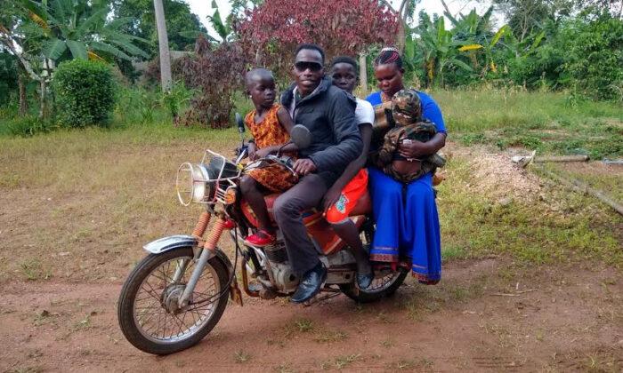 Ezira and family on a boda-boda motorbike taxi in a rural village near Kampala, Uganda, 2020. (Margaret Nelson)