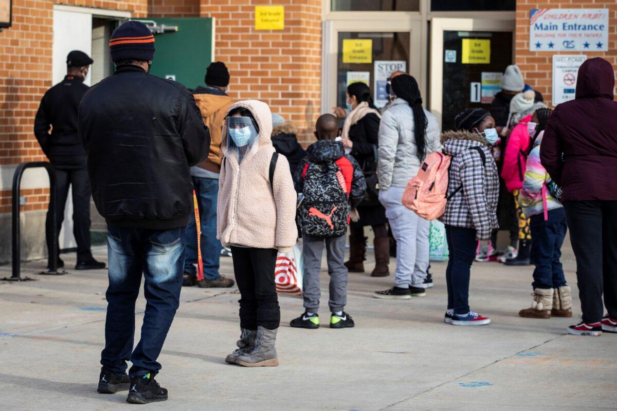 Parents and children line up outside George B. Armstrong International Studies Elementary School in Chicago on March 1, 2021. (Ashlee Rezin Garcia/Chicago Sun-Times via AP)