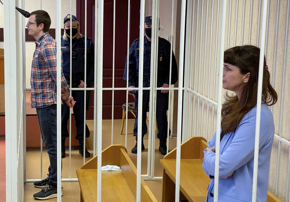 Journalist Katerina Borisevich and doctor Artyom Sorokin stand inside a defendants' cage before a court hearing in Minsk, Belarus, on March 2, 2021. (BelaPAN via Reuters)