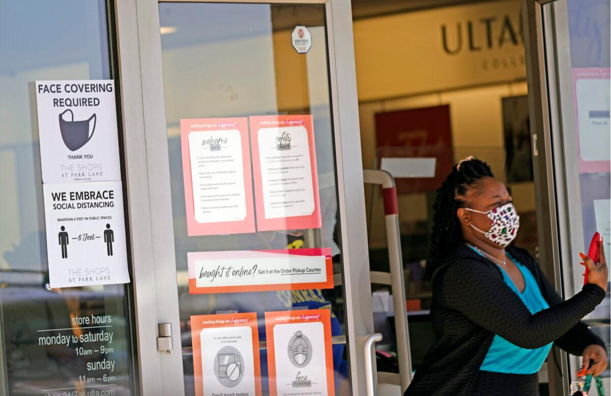 A customer exits a store with a mask required sign displayed in Dallas, Texas on March 2, 2021. (LM Otero/AP Photo)