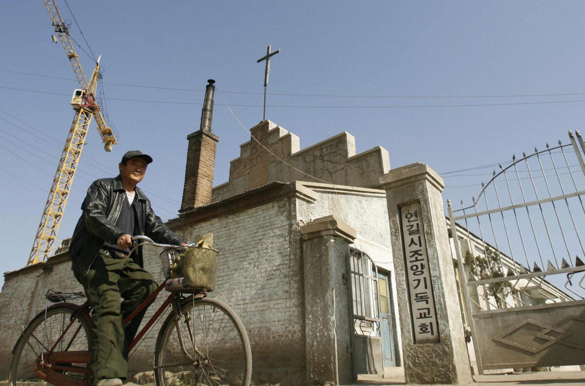 A man cycles past an Ethnic Korean Christian church in the town of Yanji in Yanbian Korean Autonomous Prefecture on the China/North Korea border in Yanji, China, on Oct. 13, 2006. (Peter Parks/AFP via Getty Images)