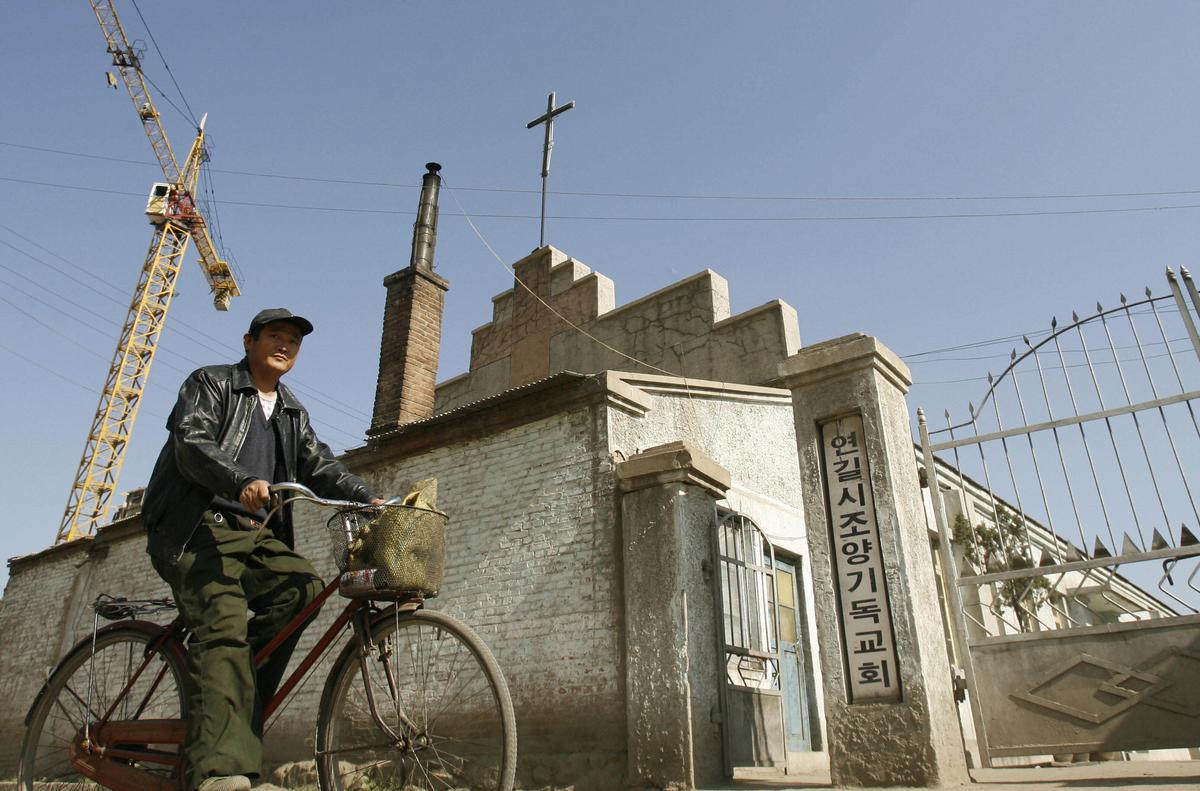 A man cycles past an ethnic Korean Christian church in the town of Yanji in Yanbian Korean Autonomous Prefecture on the China/North Korea border, Oct. 13, 2006. (Peter Parks/AFP via Getty Images)