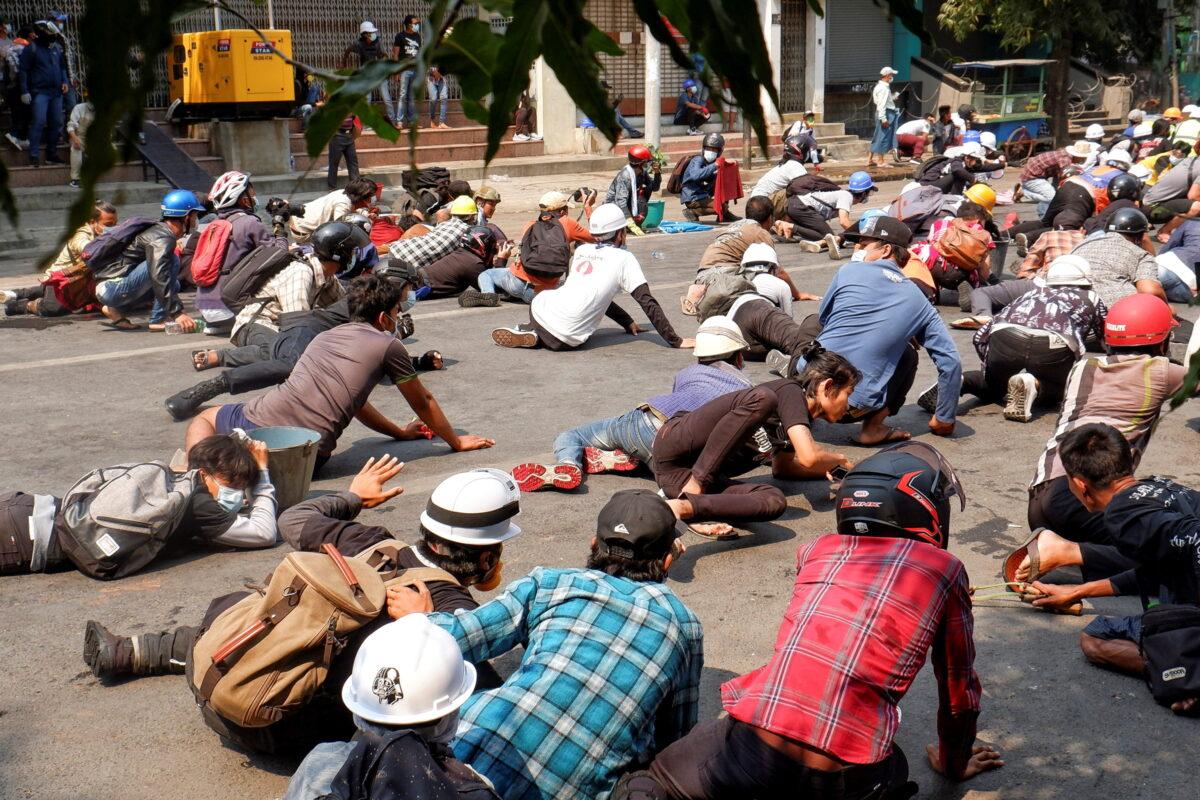 Protesters lie on the ground after police open fire to disperse an anti-coup protest in Mandalay, Burma, on March 3, 2021. (Stringer/Reuters)