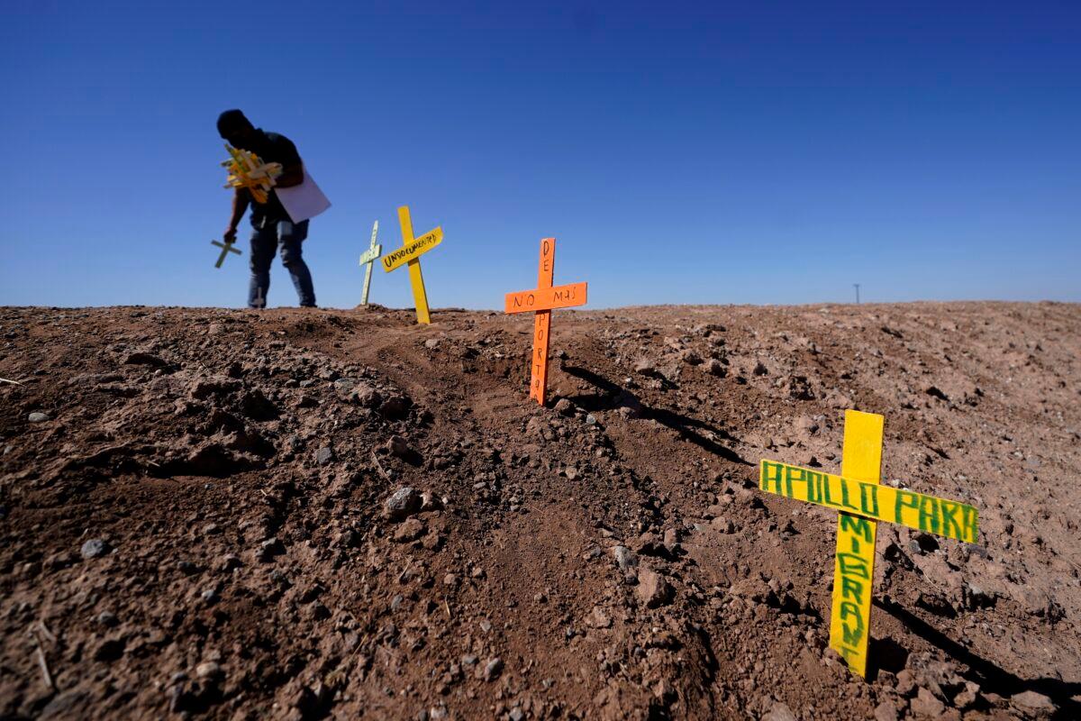 Hugo Castro leaves crosses at the scene of a deadly crash in Holtville, Calif., on March 2, 2021. (Gregory Bull/AP Photo)