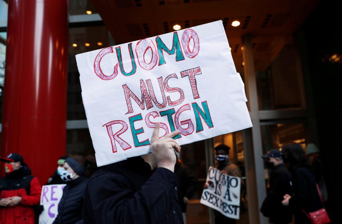 Demonstrators hold signs as they gather outside the New York Gov. Andrew Cuomo's office calling for his resignation, in the Manhattan borough of New York on March 2, 2021. (Shannon Stapleton/Reuters)
