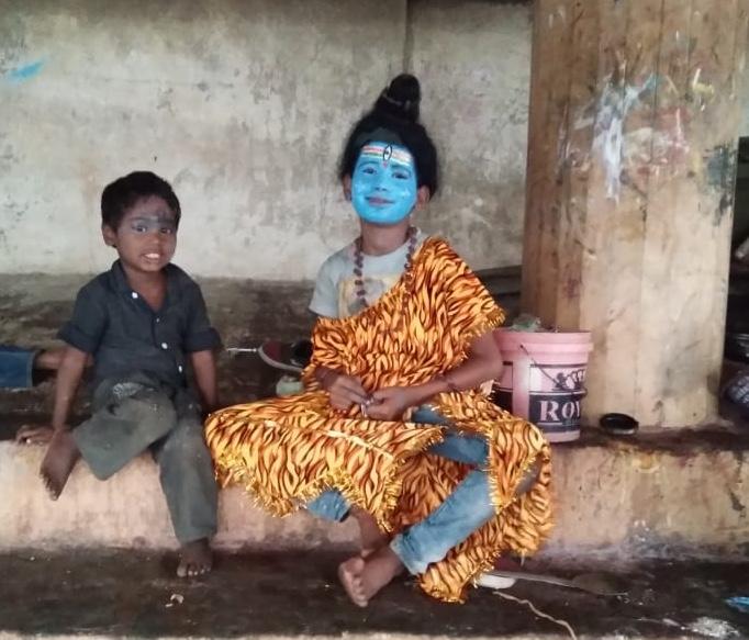 A child beggar on the bank of the river Ganges in Varanasi dresses up as a god. (Courtesy Common Man Trust)