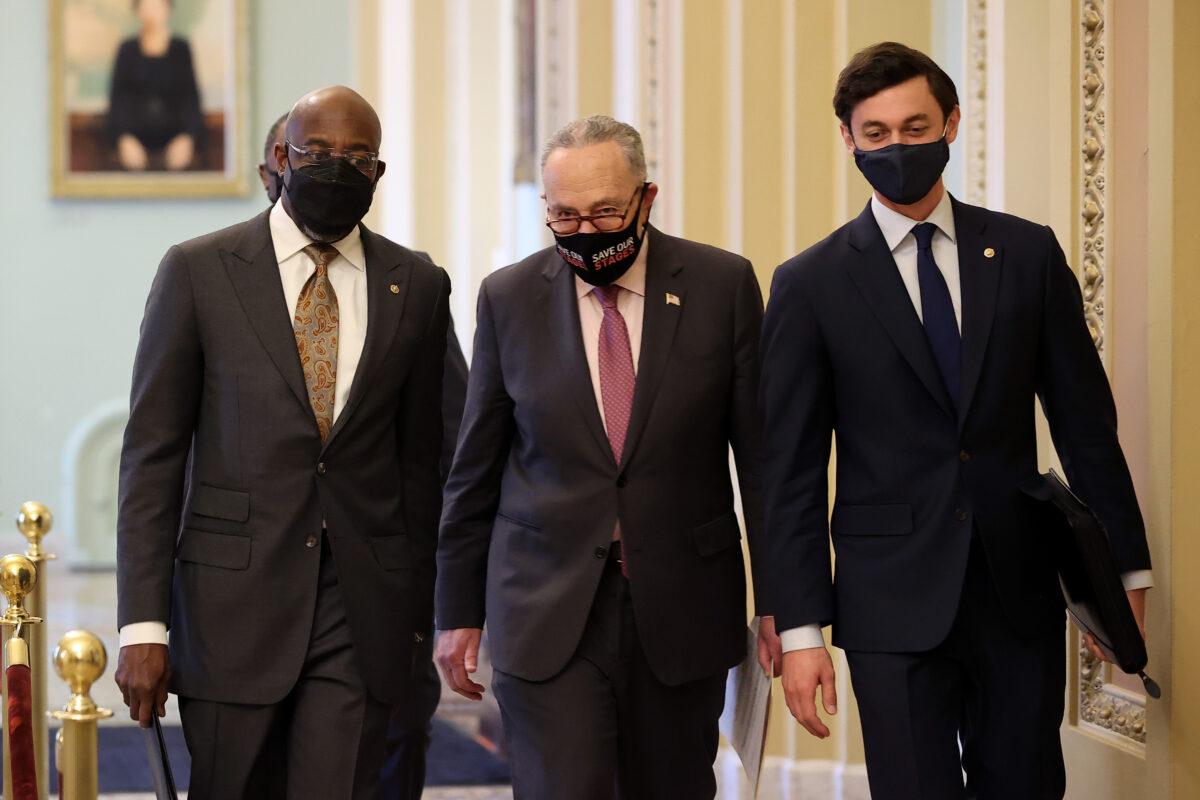 Senate Majority Leader Charles Schumer (D-N.Y.) (C) walks with Sen. Raphael Warnock (D-Ga.) (L) and Sen. Jon Ossoff (D-Ga.) on their way to a news conference at the U.S. Capitol on Feb. 11, 2021. (Chip Somodevilla/Getty Images)