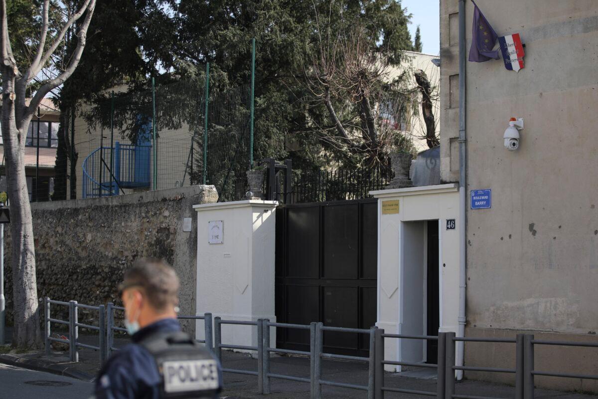 A police officer guards a Jewish school after a man visibly brandished a knife outside a Jewish school and a kosher market in Marseille, southern France, on March 5, 2021. (Daniel Cole/AP Photo)