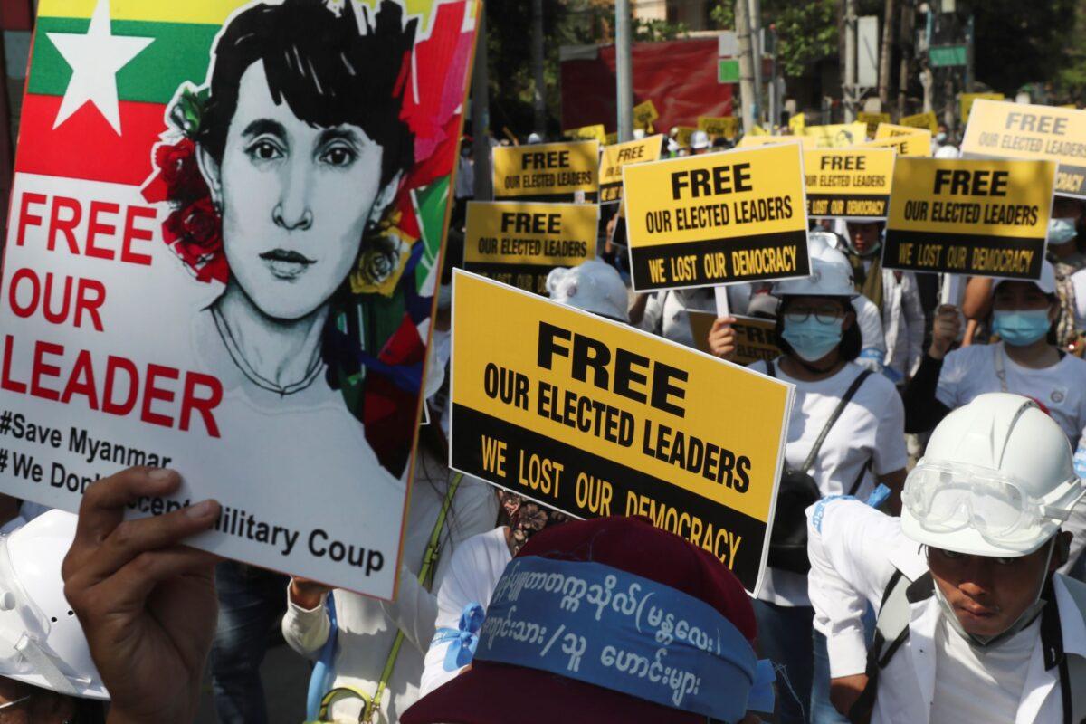  Anti-coup protesters hold signs as they gather in Mandalay, Burma, on Mar. 5, 2021. (AP Photo)