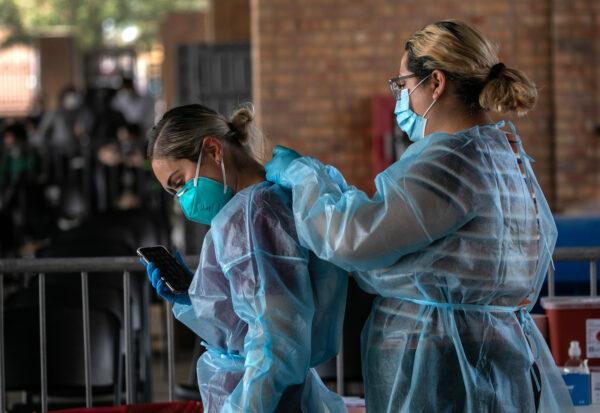 Medics suit up in PPE before testing illegal immigrants who had been released by the U.S. Border Patrolfor COVID-19, in Brownsville, Texas, on Feb. 25, 2021. (John Moore/Getty Images)