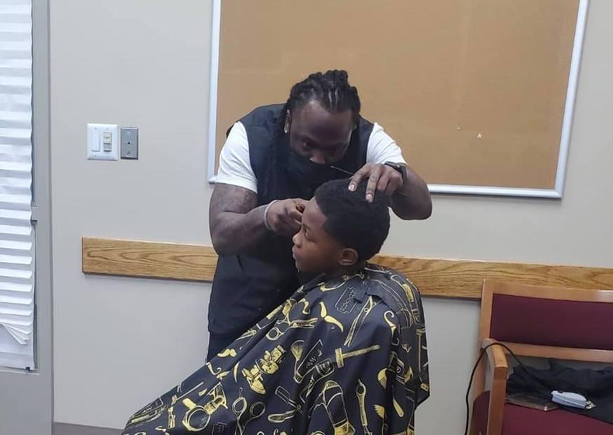 La Don Allen cuts a student's hair. (Courtesy of <a href="https://www.facebook.com/lewis.speaks">Lewis Speaks Sr.</a>)