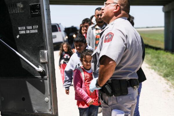 A large group of illegal aliens prepares to board a bus bound for the Border Patrol processing facility after being apprehended by Border Patrol near McAllen, Texas, on April 18, 2019. (Charlotte Cuthbertson/The Epoch Times)
