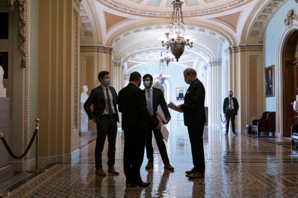 Congressional staffers wait in the ornate corridor outside the Senate chamber during a delay in work on the Democrats' $1.9 trillion COVID-19 relief bill, at the Capitol in Washington, March 5, 2021. (AP Photo/J. Scott Applewhite)