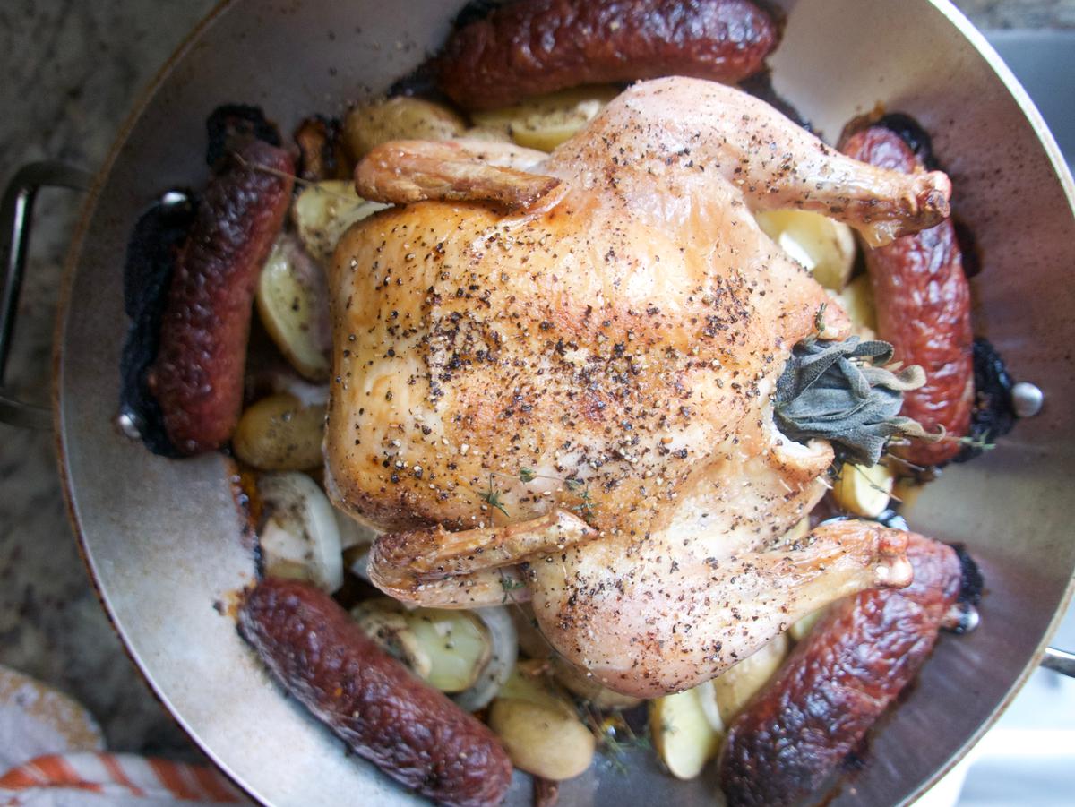 Arrange the chicken and sausages on a bed of baby potatoes, so they absorb all the juices and flavor from the meat as they roast. (Victoria de la Maza)