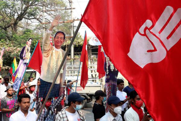 Protesters holds a portrait of deposed President Win Myint and leader Aung San Suu Kyi, during a demonstration in Mandalay, Burma, on March 8, 2021. (AP Photo)