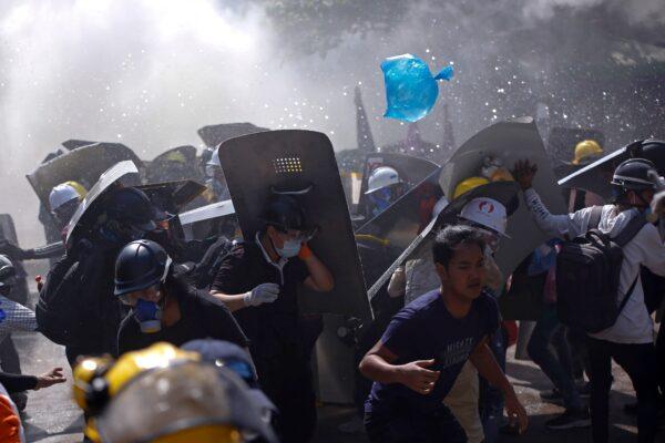 Protesters are dispersed as riot police fire tear gas during a demonstration in Yangon, Burma, on March 8, 2021. (AP Photo)