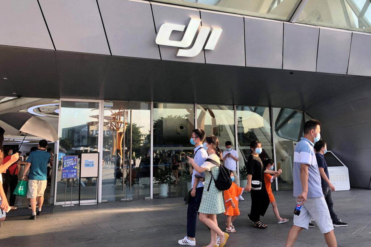 People wearing face masks following the coronavirus disease outbreak walk past DJI's flagship store in Shenzhen, Guangdong Province, China, on Aug. 8, 2020. (David Kirton/Reuters)