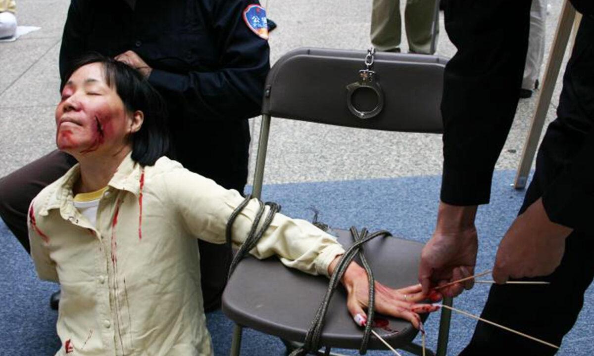 Reenactment of one of the torture methods employed by Chinese officials to coerce Falun Gong practitioners to renounce their faith. (Courtesy of Minghui.org)