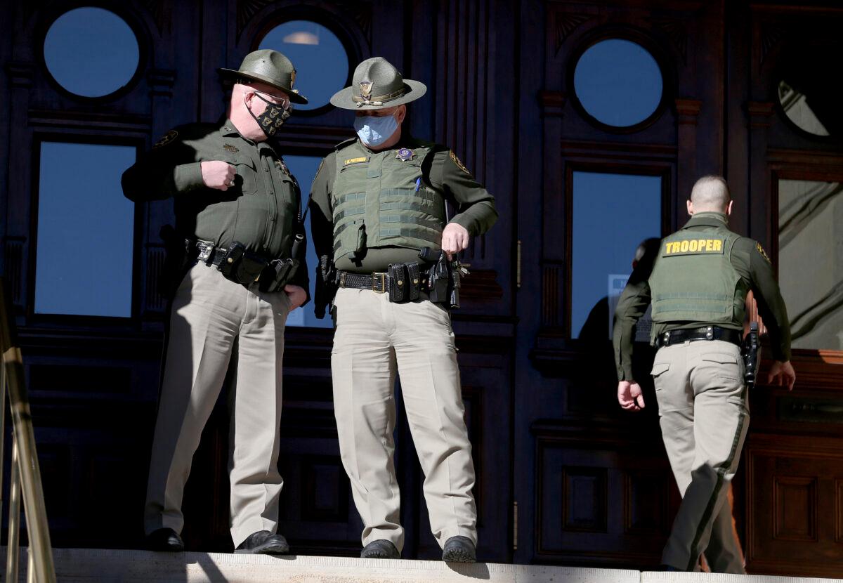 Wyoming Highway Patrol troopers talk outside the Wyoming State Capitol Building in Cheyenne, Wyo., on Jan. 6, 2021. (Michael Cummo/Wyoming Tribune Eagle via AP)