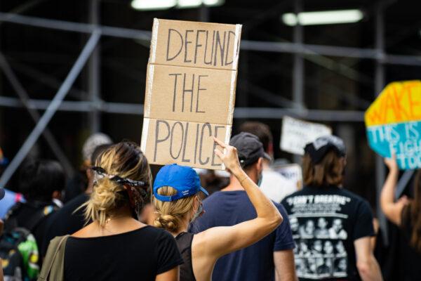A protester is holding a 'defund the police' sign at a Black Lives Matter protest in Manhattan, New York City, on July 13, 2020. (Chung I Ho/The Epoch Times)
