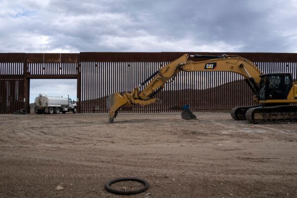 A caterpillar parks between fences at a reinforced section of the U.S.-Mexico border fencing in eastern Tijuana, Baja California state, Mexico, on Jan. 20, 2021. (Guillermo Arias/AFP via Getty Images)