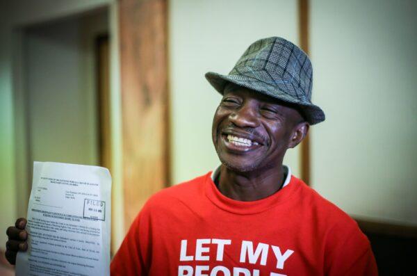 Leonel Frage, 60, who hasn't been able to vote in more than 15 years due to a felony conviction, poses proudly holding a paper restoring his right to vote during a special court hearing in a Miami-Dade County courtroom in Florida on Nov. 8, 2019. (Zak Bennett/AFP via Getty Images)