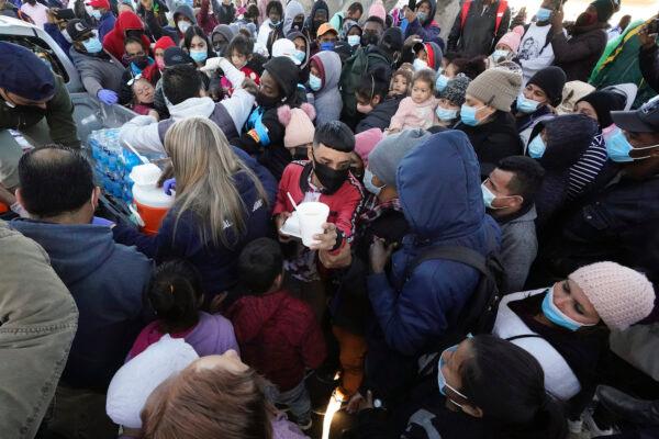 Alien migrants receive food as they wait for news at the border, in Tijuana, Mexico, on Feb. 19, 2021. (AP Photo/Gregory Bull)