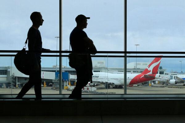 Two passengers walk past a Qantas jet at the International terminal at Sydney Airport on March 10, 2020, in Sydney, Australia. (Mark Evans/Getty Images)