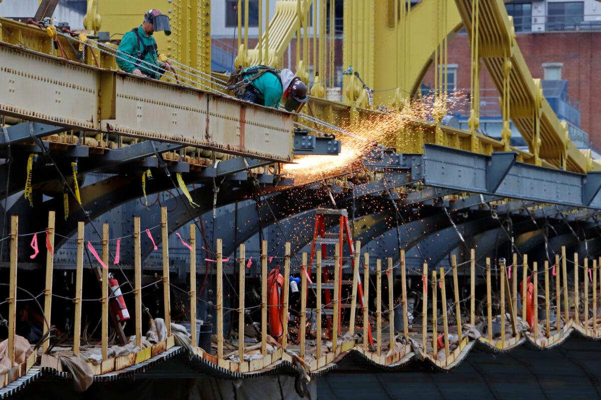 A worker welds on the Ninth Street bridge in Pittsburgh, Pa., on May 6, 2020. (Gene J. Puskar/AP Photo)
