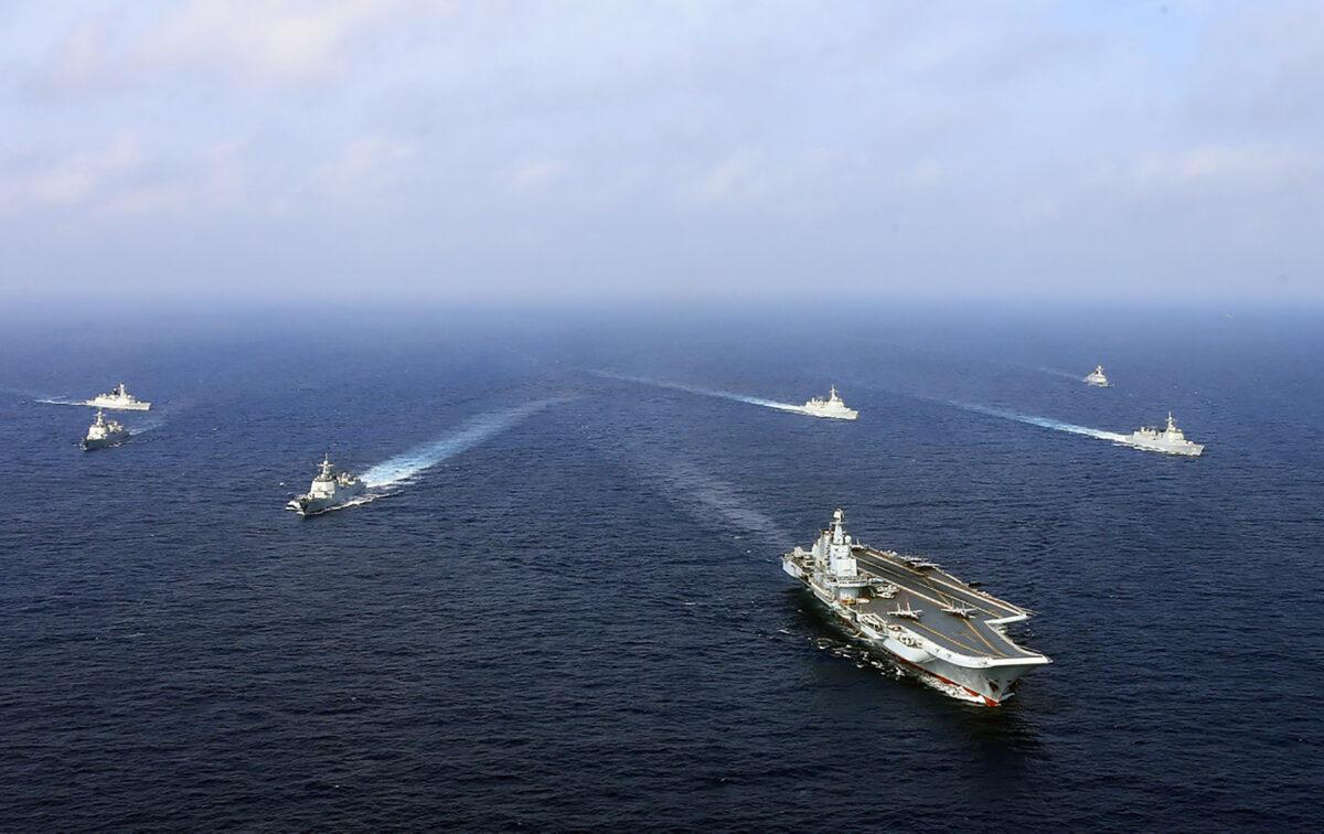 China's operational aircraft carrier, the Liaoning (front), sailing with other ships during a drill at sea on April 2018. A flotilla of Chinese naval vessels held a "live combat drill" in the East China Sea—as state media reported on April 23, 2018—the latest show of force by Beijing's burgeoning navy in disputed waters that have riled neighbors. (AFP via Getty Images)