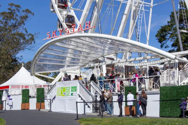 People wait in line to ride the SkyStar Wheel in Golden Gate Park in San Francisco on March 6, 2021. (David Lam/The Epoch Times)