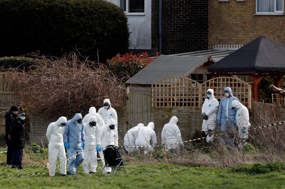 Police officers search an area of grass land behind a house, as the investigation into the disappearance of Sarah Everard continues, in Deal, Britain, on March 12, 2021. (Paul Childs/Reuters)