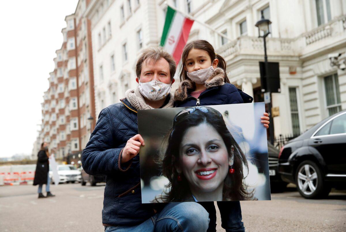 Richard Ratcliffe, husband of British-Iranian aid worker Nazanin Zaghari-Ratcliffe, and their daughter Gabriella protest outside the Iranian Embassy in London, on March 8, 2021. (Andrew Boyers/Reuters)