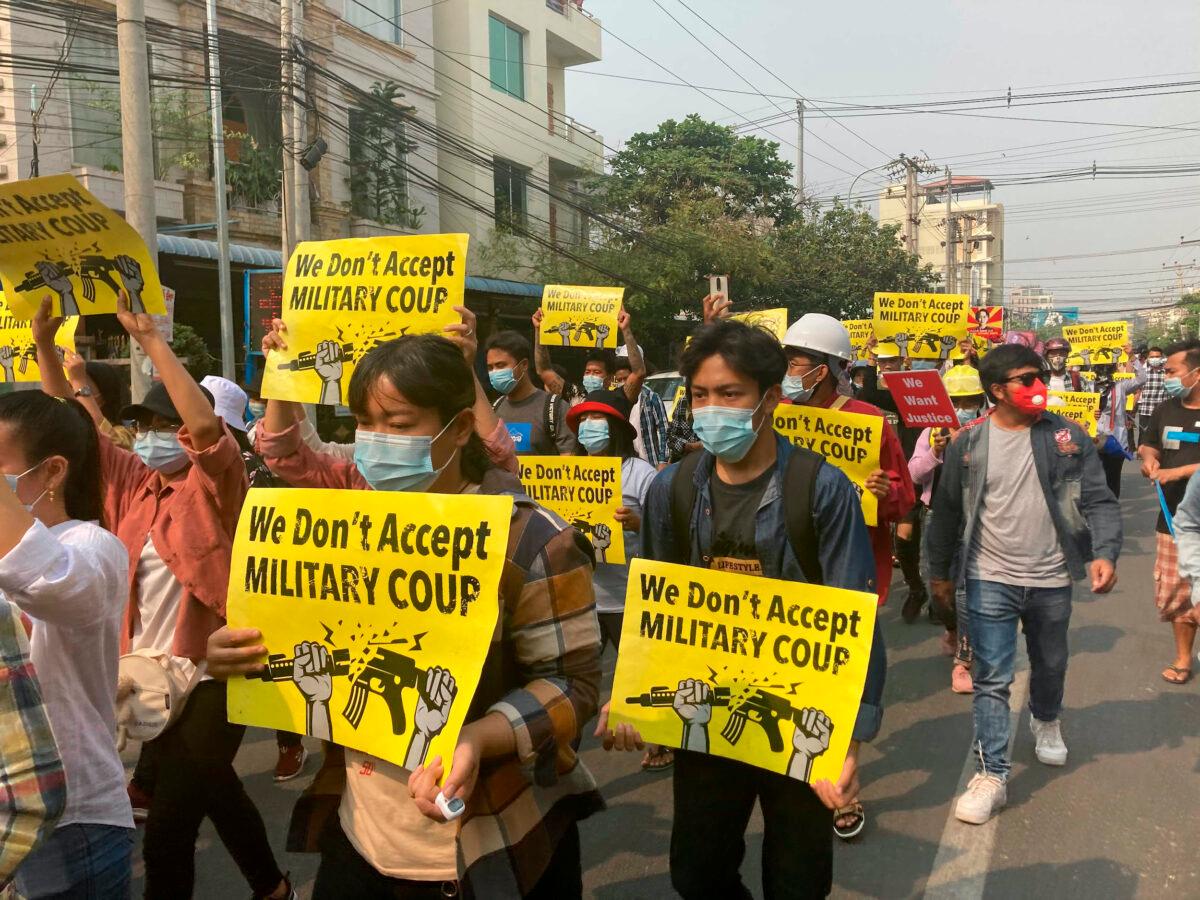 Anti-coup protesters hold signs that read 'We don't accept military coup' during a march in Mandalay, Burma, on Sunday, March 14, 2021. (AP Photo)