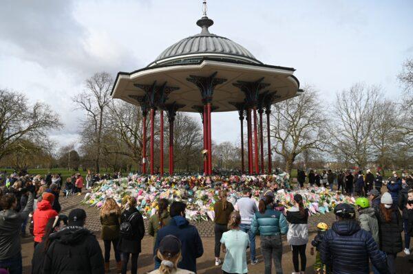 Well-wishers gather beside floral tributes to honour alleged murder victim Sarah Everard at the bandstand on Clapham Common in south London on March 14, 2021. (Daniel Leal-Olivas/AFP via Getty Images)
