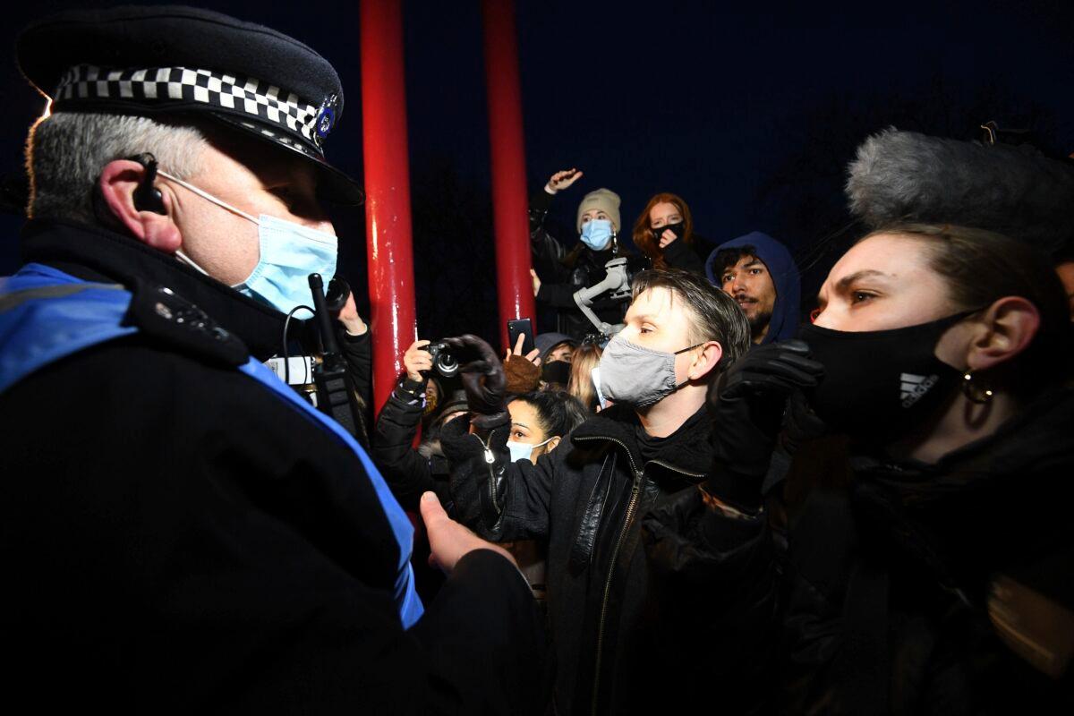 People react with police, in Clapham Common as people gather, despite the Reclaim These Streets vigil for Sarah Everard being officially cancelled, in London, on March 13, 2021. (Victoria Jones/PA via AP)