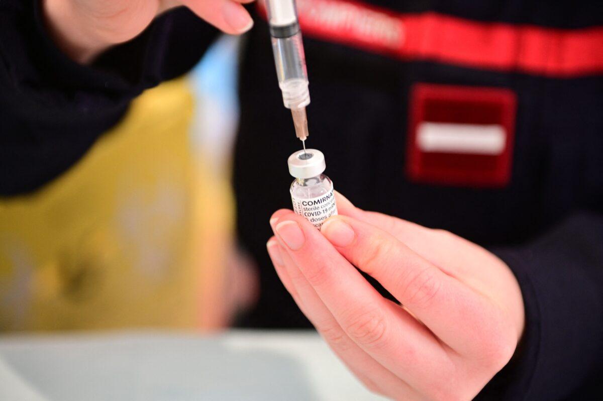 A firefighter prepares a vaccination against COVID-19 at the Gymnase Le Moulin in Cergy, a northwestern suburbs of Paris, France, on March 13, 2021. (Martin Bureau/AFP via Getty Images)