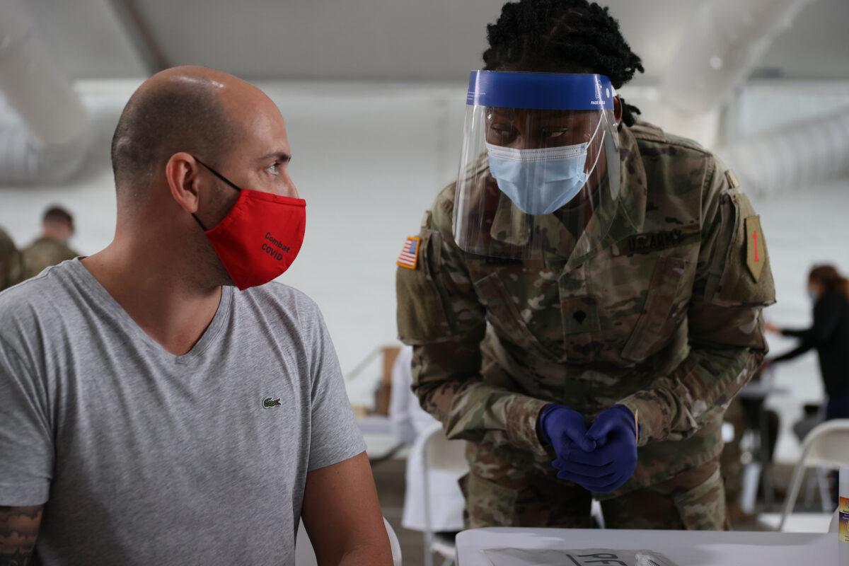 A U.S. Army soldier prepares to immunize a man with a COVID-19 vaccine in North Miami, Fla., on March 9, 2021. (Joe Raedle/Getty Images)