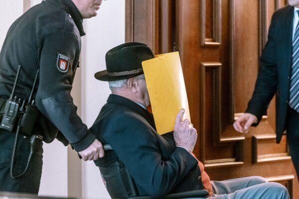 Bruno Dey, a former SS watchman at the Stutthof concentration camp in Poland, covers his face as he is brought out of a courtroom during his trial in Hamburg, Germany, on Feb. 26, 2020. In July 2020, 93-year-old Dey was found guilty of complicity in the murder of more than 5,000 prisoners and was given a two-year suspended prison sentence. (Markus Scholz/Pool/AFP via Getty Images)
