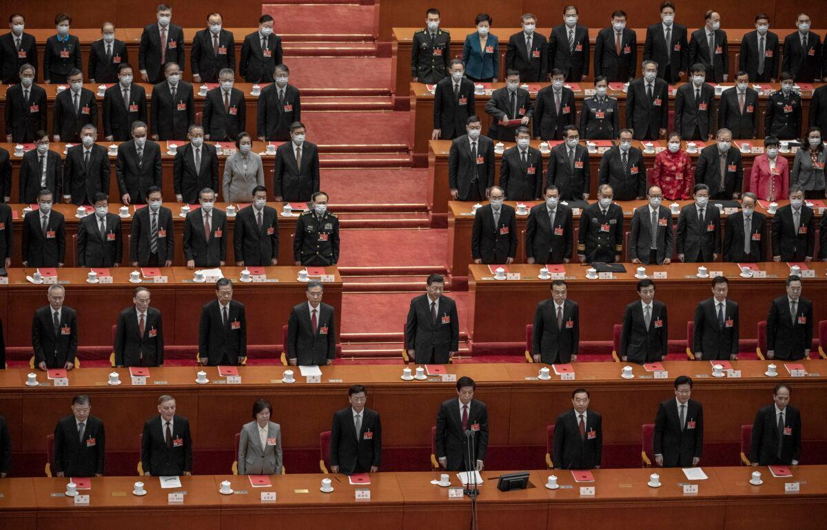 Chinese leader Xi Jinping (center) and lawmakers stand for the anthem during the closing session of the rubber-stamp legislature’s conference at the Great Hall of the People in Beijing, China, on March 11, 2021. (Kevin Frayer/Getty Images)
