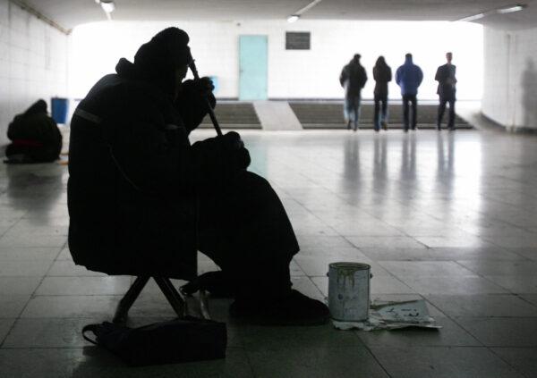 Pedestrians ignore the poor and elderly in a Beijing subway on Dec. 14, 2005. (Frederic J. Brown/AFP via Getty Images)